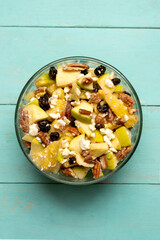 Apple salad with walnuts for Christmas on a turquoise background