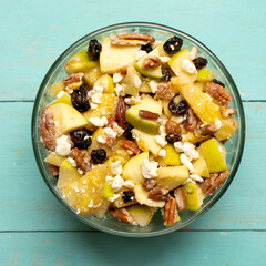 Apple salad with walnuts for Christmas on a turquoise background