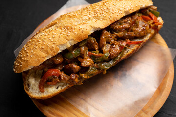 Philly cheese steak with bell pepper on dark background