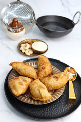 Indian Holi snack popuraly known as Gujia or Gujiya. Also called Karanji in Maharashtra, mostly eaten during Diwali. It is a deep fried sweet dish made from maida and stuffed with khoya or rava. copy.