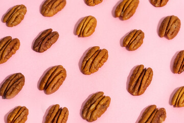 Walnuts creating a pattern on a pink background