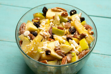 Apple salad with walnuts for Christmas on a turquoise background