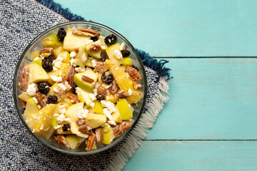 Apple salad with walnuts for Christmas on a turquoise background