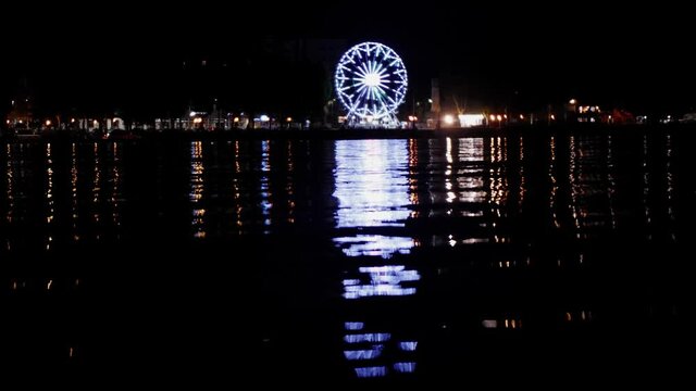 Reflection of a Ferris wheel in the lake at night