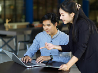 Businessman and businesswoman working together on laptop computer