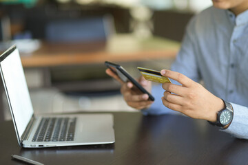 A man or businessman holding credit card and smartphone