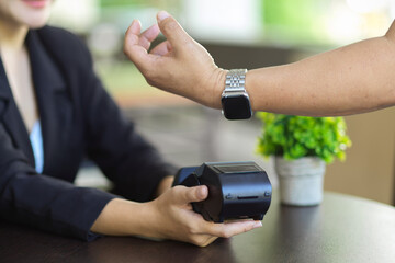 a man using his modern smartwatch to pay on online payments