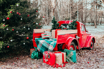 red car pickup truck decorated with Christmas wreath, blankets, pillows and gift boxes with...