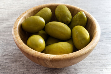 Bowl with Italian green olives from Cerignola. Bella di Cerignola Italian olives on wooden table