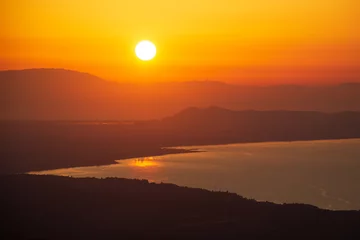 Fototapeten orange sunset over the sea and mountains © Юрий Надёжин