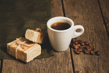 a piece of peanut halva and a cup of coffee on the table for breakfast, halva and coffee