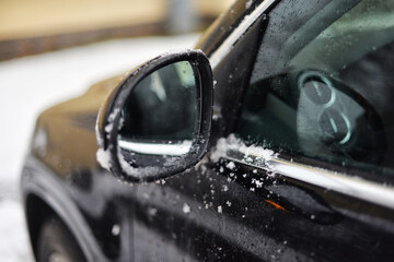 Side mirror in the snow in winter