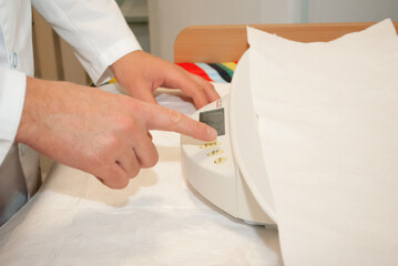a doctor in a white coat presses the button of the scale for newborns going to undergo a medical examination with a small child before vaccination against coronavirus Pediatrician
