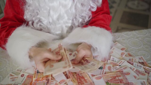 top view. hands of santa claus counts money on the table. Rubles. income of toy and actor stores during the Christmas holidays. investments in shares and securities. 