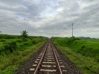 Fototapeta na wymiar railroad track near green countryside