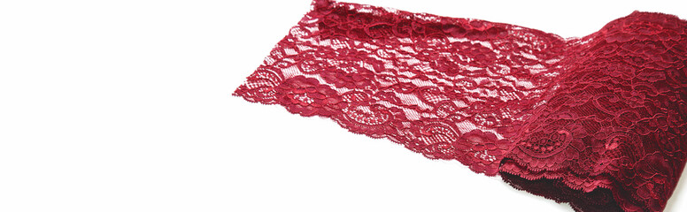 Texture lace fabric. lace on white background studio. a background image of red colored lace cloth. Burgundy lace on white background.