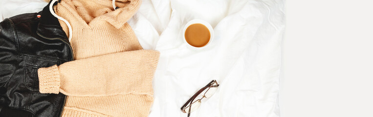 leather jacket and warm sweater , glasses, a cup of coffee, notepad on white sheet womens stylish autumn or spring