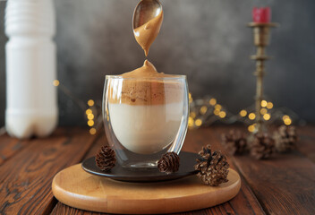 Dollops of frothed coffee and sugar mixture added on top milk to make dalgona coffee