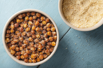 Bowl of fried chickpeas and a bowl of grated cheese with spices top view