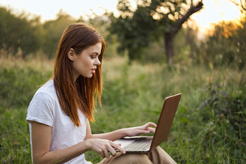 women outdoors in field with laptop leisure technology freedom