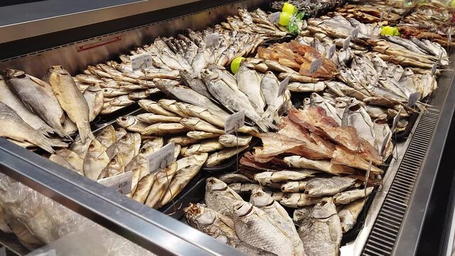 Dry and dried fish are sold in a shop window. Beer snack, background