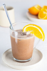 Mochaccino coffee with chocolate and orange juice in a glass mug.