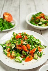 Mediterranean salad with tomatoes, cucumber, coriander, onions, olive oil and lemon in a white ceramic plate. Healthy vegetarian food, oriental and Mediterranean cuisine. Top view. Copy space. No.07