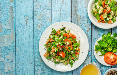 Mediterranean salad with tomatoes, cucumber, coriander, onions, olive oil and lemon in a white ceramic plate. Healthy vegetarian food, oriental and Mediterranean cuisine. Top view. Copy space. No.03