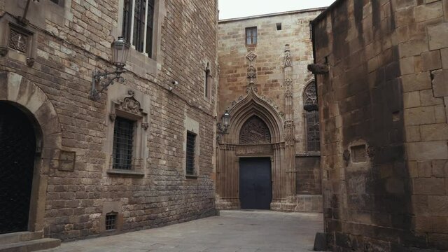 Barcelona - Carrer de la Pietat with ancient doorways, barred windows and the stone walls of the Cathedral of Barcelona