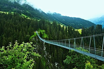 Fototapeta premium Austrian Alps - view of the rope suspension bridge high above the Höhenbachtal near the town of Holzgau in the Lechtal Alps
