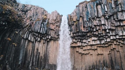 Low angle view looking up at majestic Svartifoss Waterfall, Iceland. Static.