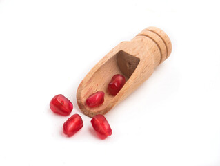 scoop with pomegranate seeds on white background