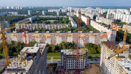 Obraz premium New high-rise apartment buildings under construction. Aerial photo at sunny evening