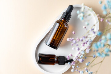 Obraz na płótnie Canvas top view of two dark glass pipette bottles with essential oil and collagen for skin care. Unbranded package with copy space. Designers mokup