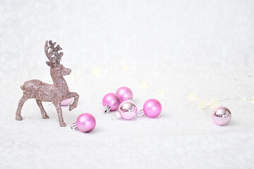Object decorated christmas background, pink christmas ball and small gilter pink dear toy on white fur with blackground with space for text. .Holiday concept.