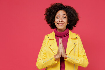 Pleading young curly black latin woman 20s wears yellow jacket hands folded in prayer gesture beg...