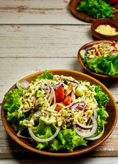 Homemade salad with dressing,cucumber, tomatoes,lettuce,shallot and cream cheese.  Rustic style. Selective Focus. Top view. Copy space. No.09
