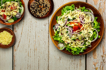 Homemade salad with dressing,cucumber, tomatoes,lettuce,shallot and cream cheese.  Rustic style. Selective Focus. Top view. Copy space. No.06