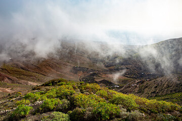 Clouds, fog and rain over a green volcanic mountain on Lanzarote.