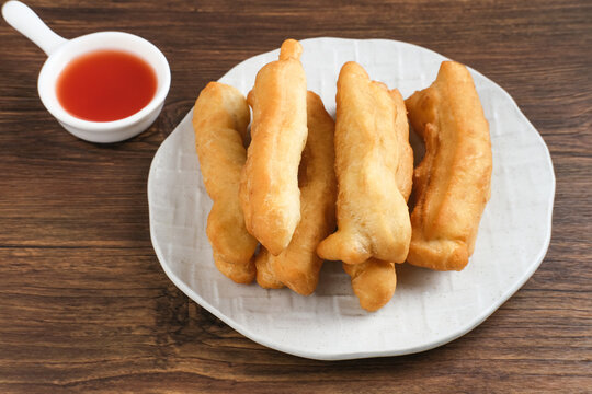 Cakwe or Cakue or Youtiao is traditional Chinese snack, long golden-brown deep-fried strip of dough and very popular in China and Asia. Selective focus image, copy space.
