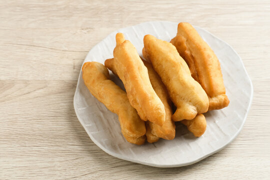 Cakwe or Cakue or Youtiao is traditional Chinese snack, long golden-brown deep-fried strip of dough and very popular in China and Asia. Selective focus image, copy space.
