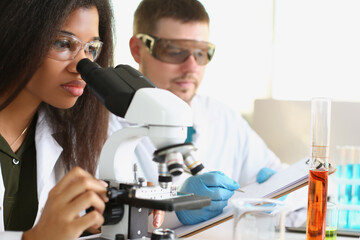 Fototapeta na wymiar A black woman and a white man are working in the laboratory