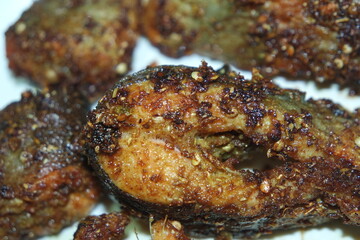 Spicy and crunchy barbecue of fried fish fillet on a white background