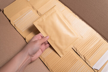Woman hand holding bubble envelope for postal shipping
