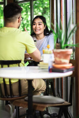 Couple sitting in a coffee shop talking and drinking coffee.