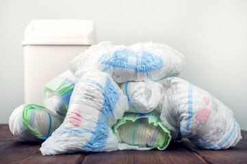 Diapers waste, dirty diapers in garbage pail Disposing of used baby nappies. Environmental Impact...