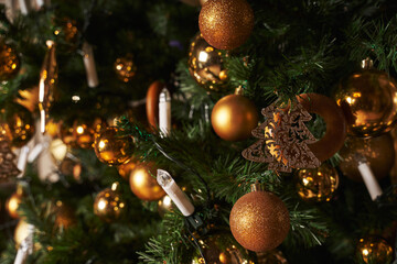 Obraz na płótnie Canvas golden toys decorations on the christmas tree and a garland in the form of candles