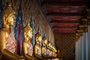 Row of Buddha image in meditation posture
 lined up at Wat Pho temple in Bangkok, Thailand.
