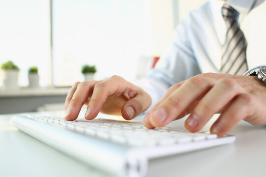 A man is typing on the keyboard, hands close-up