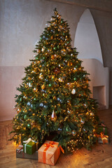 beautiful decorated tall christmas tree with boxes of gifts underneath